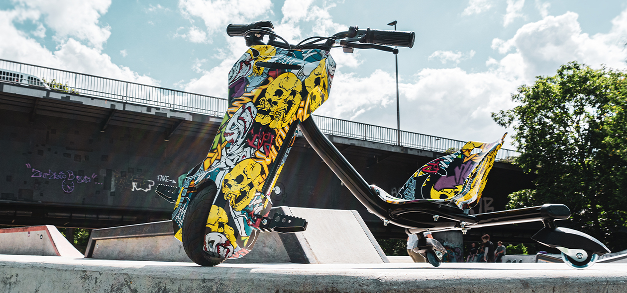 Elektro-Drift-Trike 360 mit gelbem Printmuster auf Skaterpiste