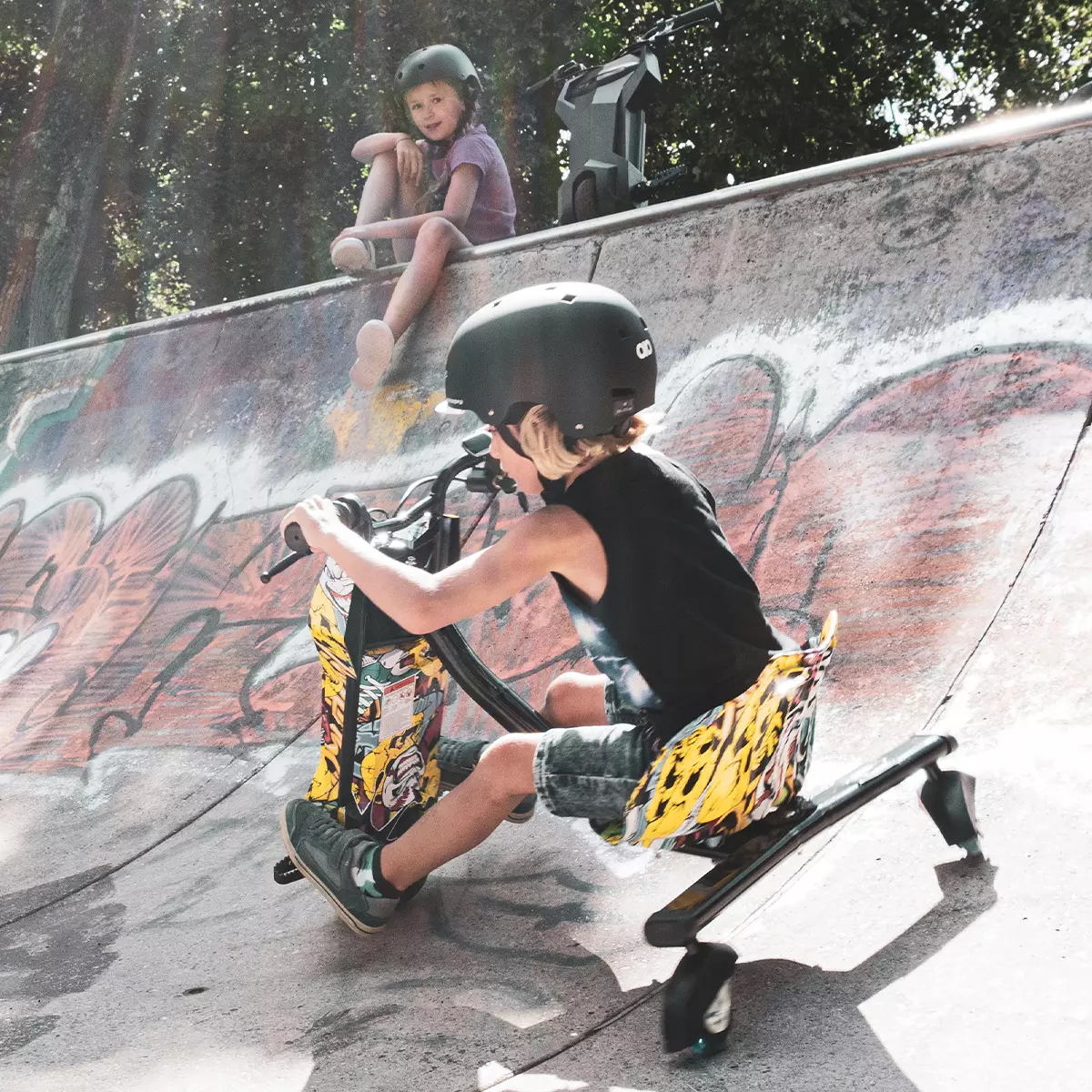 Junge steuert das Elektro-Drift-Trike 360 über die schräge Wand einer Skaterpiste