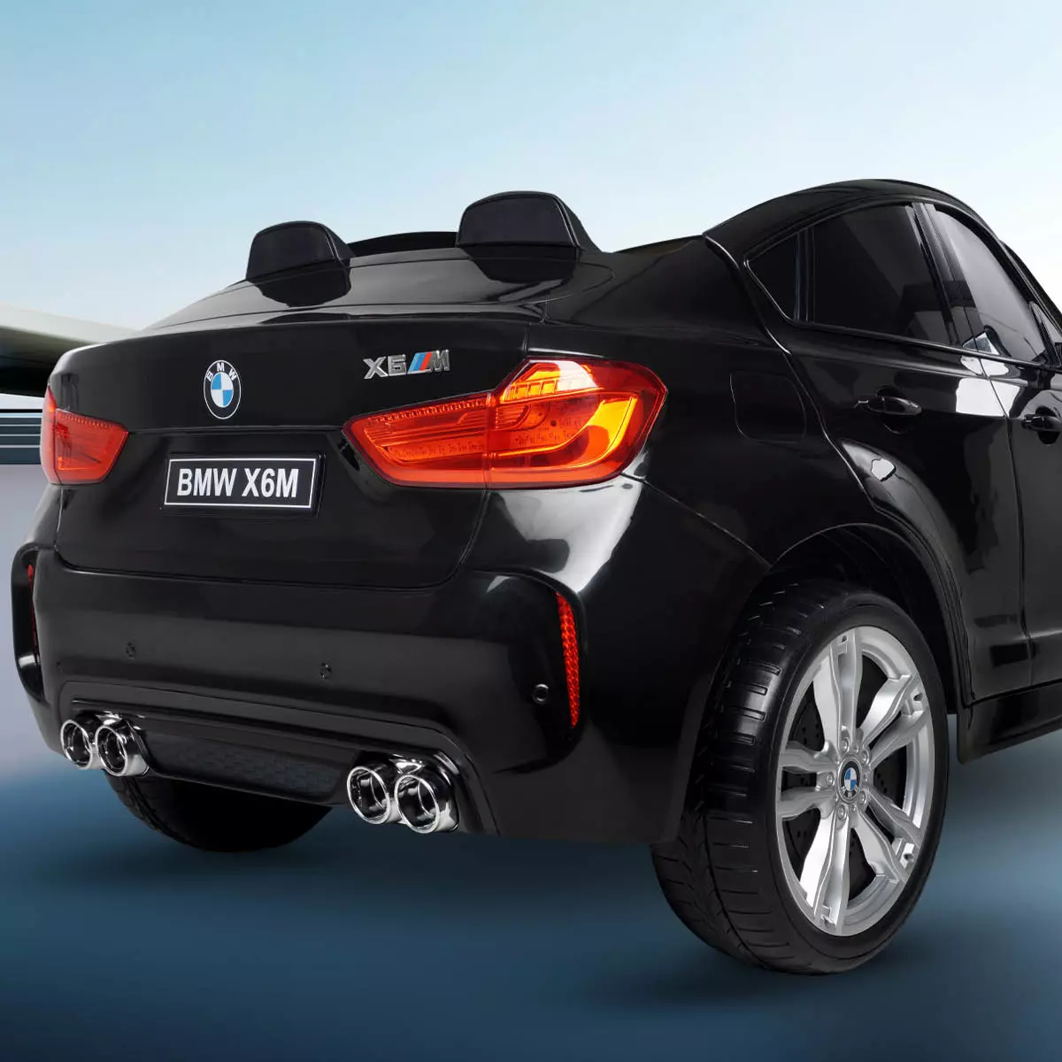Schwarzes BMW Kinderauto von hinten mit zwei Rückleuchten, BMW-Emblem und Nummernschild