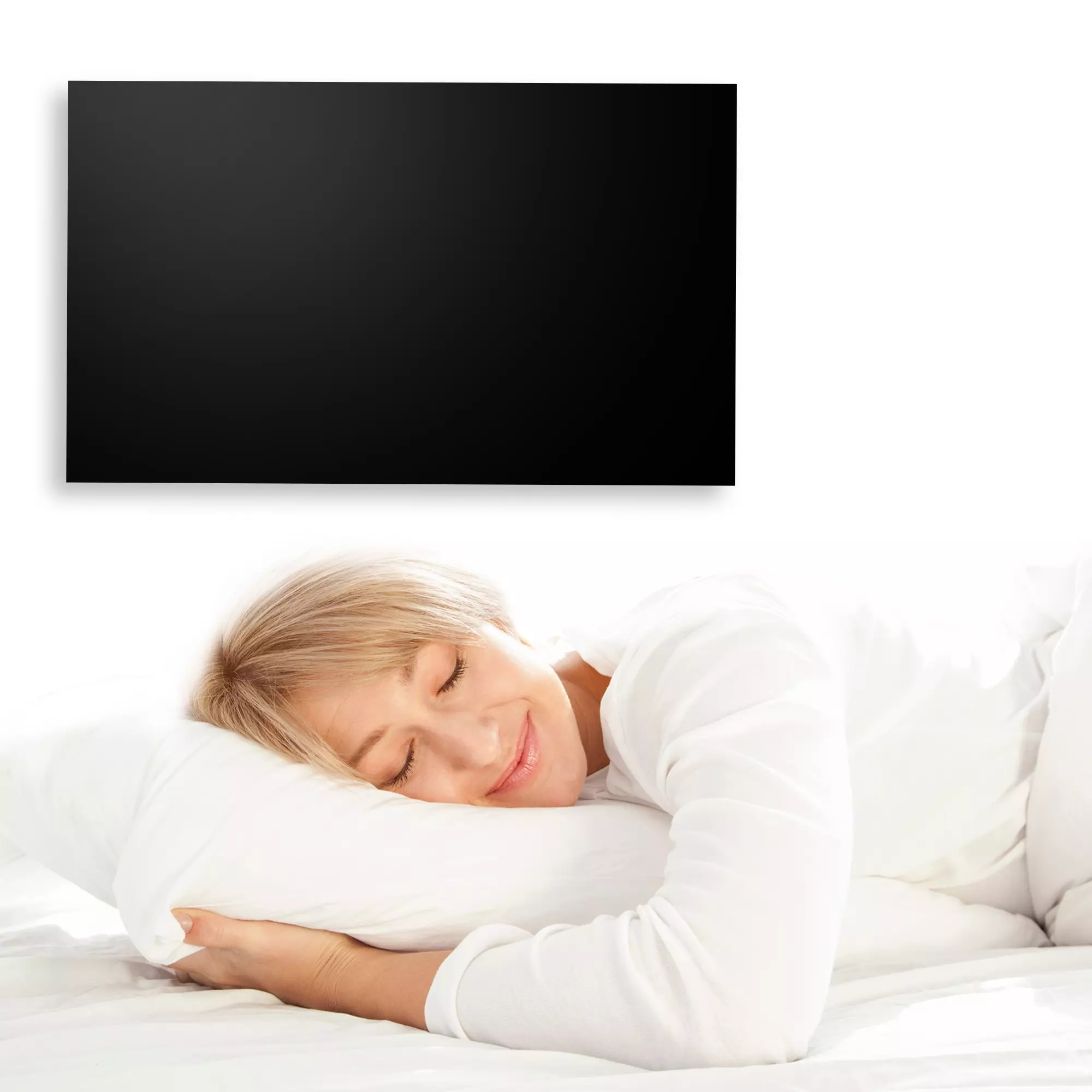 Heidenfeld Infrarotheizung in Schwarz an Schlafzimmerwand, Frau schläft lächelnd im Bett