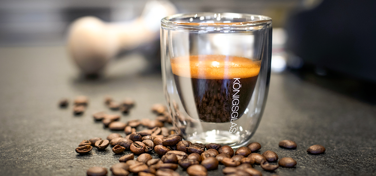 Schwarzer Kaffee mit goldenem Schaum im doppelwandigen Espresso-Glas