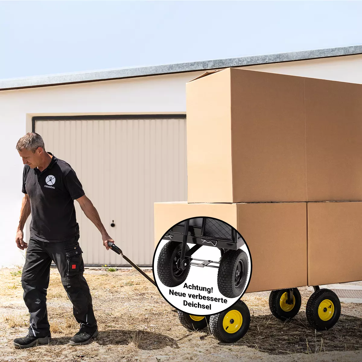 Ein Mann transportiert große Kartons auf der Ladefläche des Bollerwagens im Hof